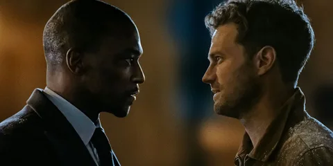 Deux hommes se regardent intensément dans une scène dramatique.