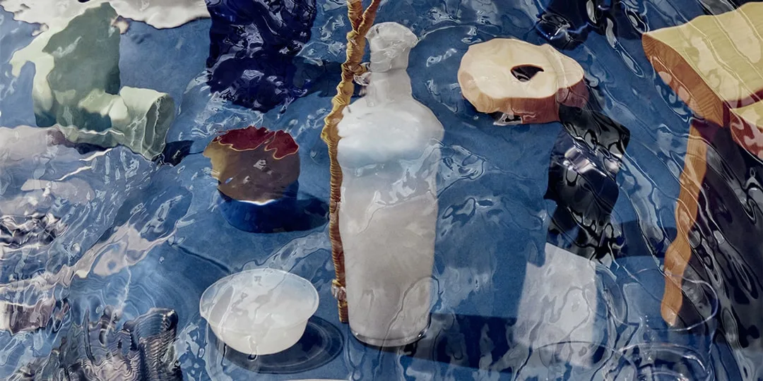 Objets artistiques variés déformés par l'eau sur une surface bleue.