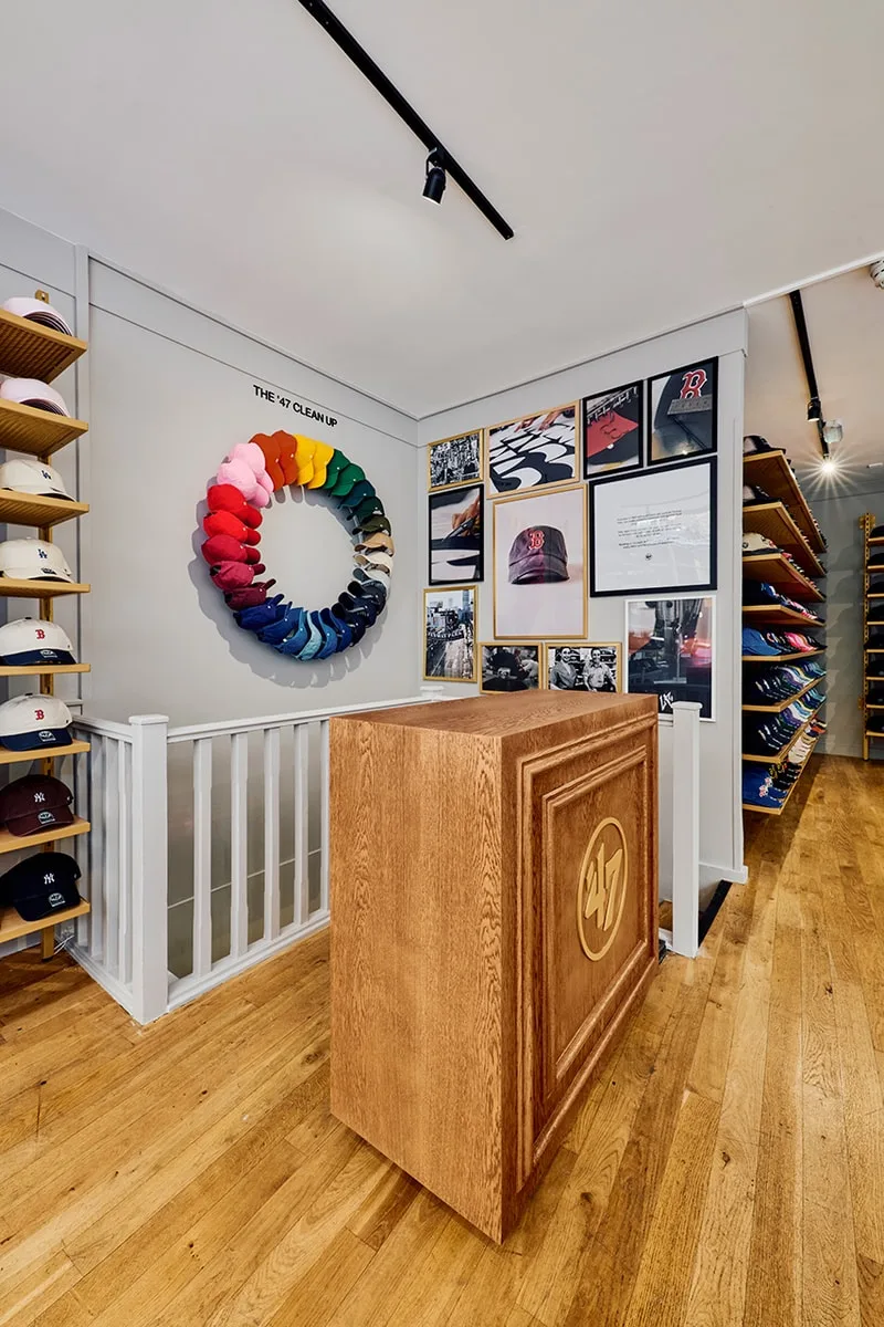 Intérieur d'une boutique de casquettes avec présentoir circulaire coloré.