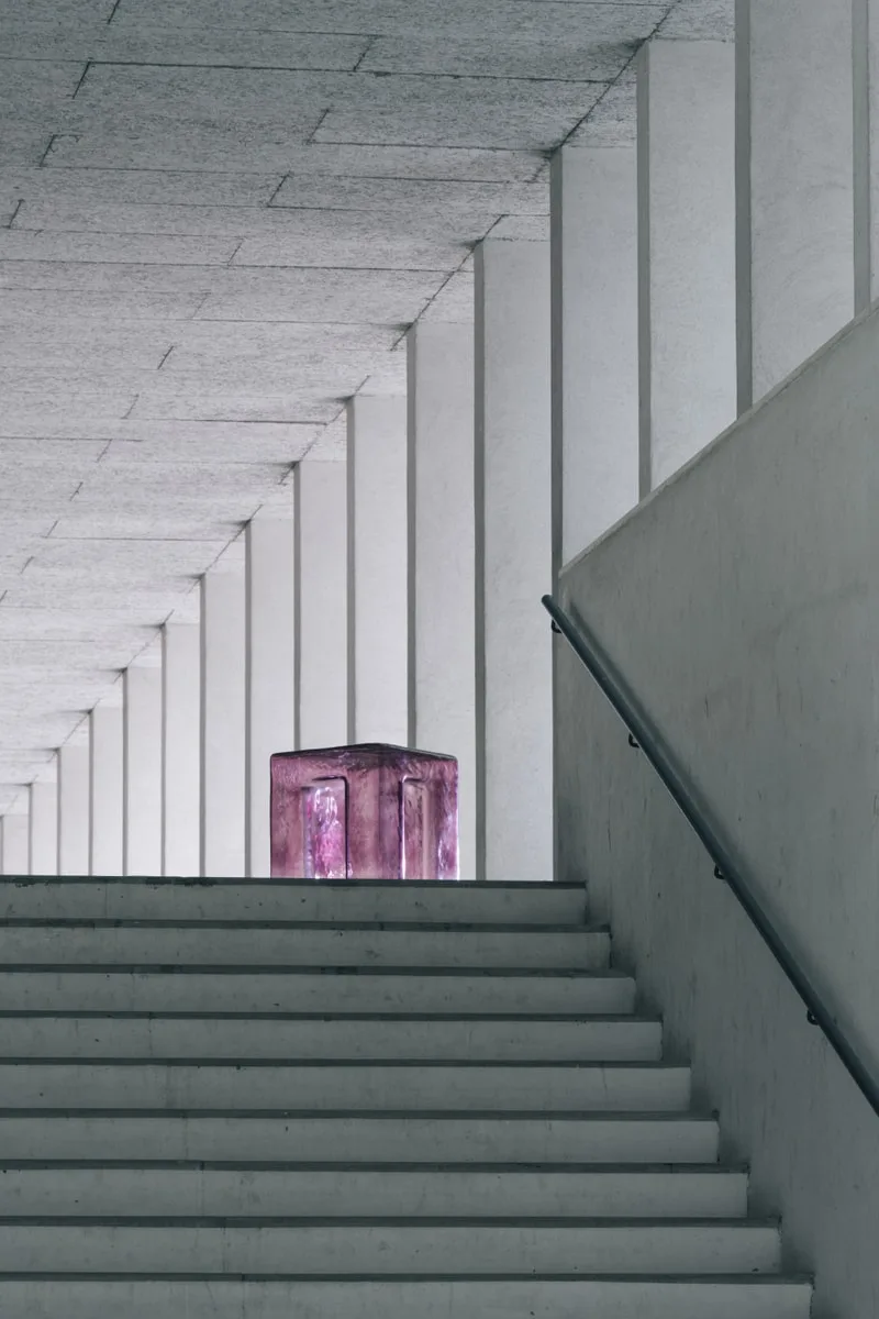 Intérieur moderne avec cube violet sur un escalier blanc.