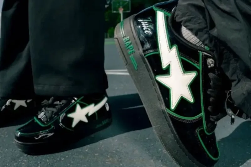 Chaussures noires avec détails verts et blancs sur un terrain de basket