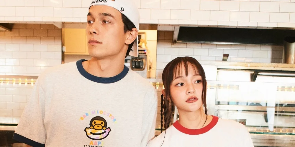 Un homme et une femme dans une cuisine, portant des t-shirts décontractés.