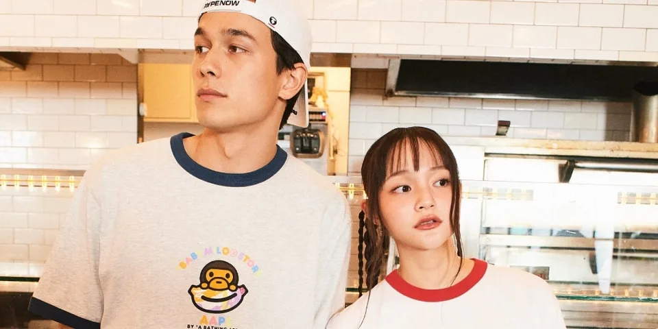 Un homme et une femme dans une cuisine, portant des t-shirts décontractés.