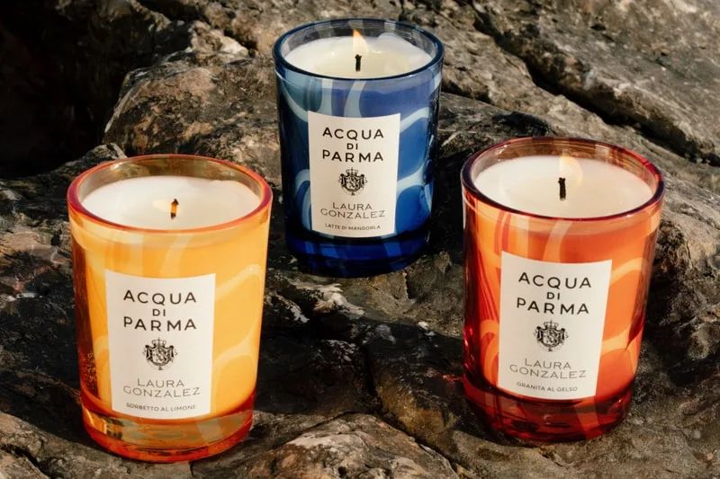 Trois bougies parfumées sur des rochers, étiquetées Acqua di Parma.