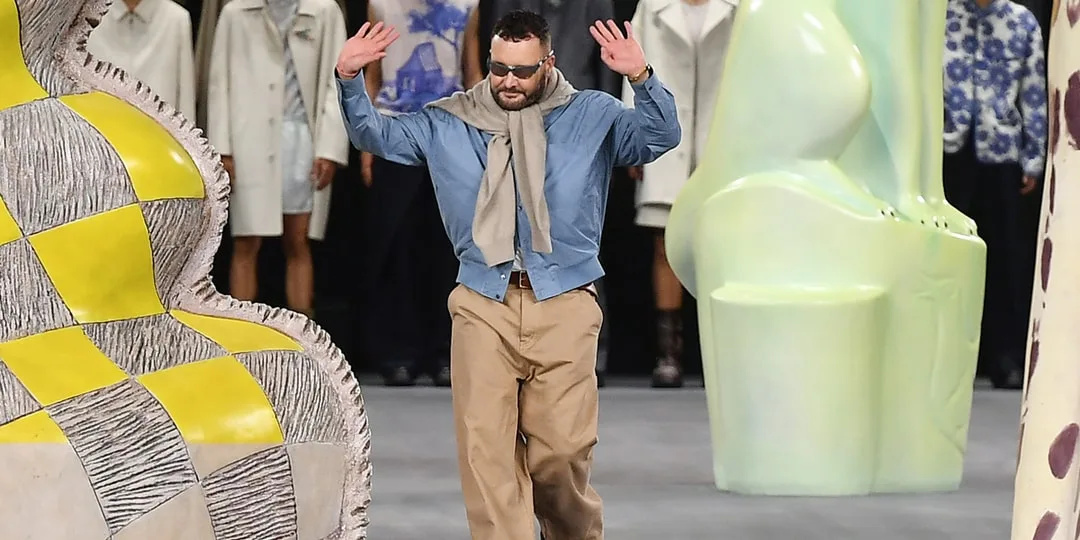 Un mannequin défile entre des sculptures colorées lors d’un défilé de mode.