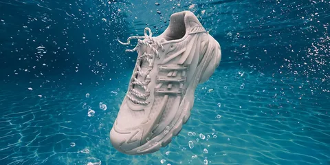 Basket blanche flottant dans l'eau avec des bulles autour.