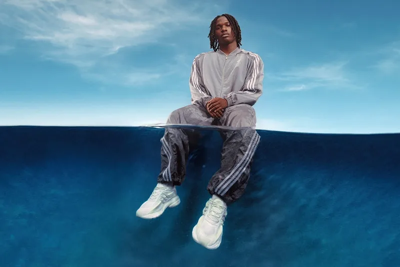 Homme assis sur l'eau en tenue de sport adidas.