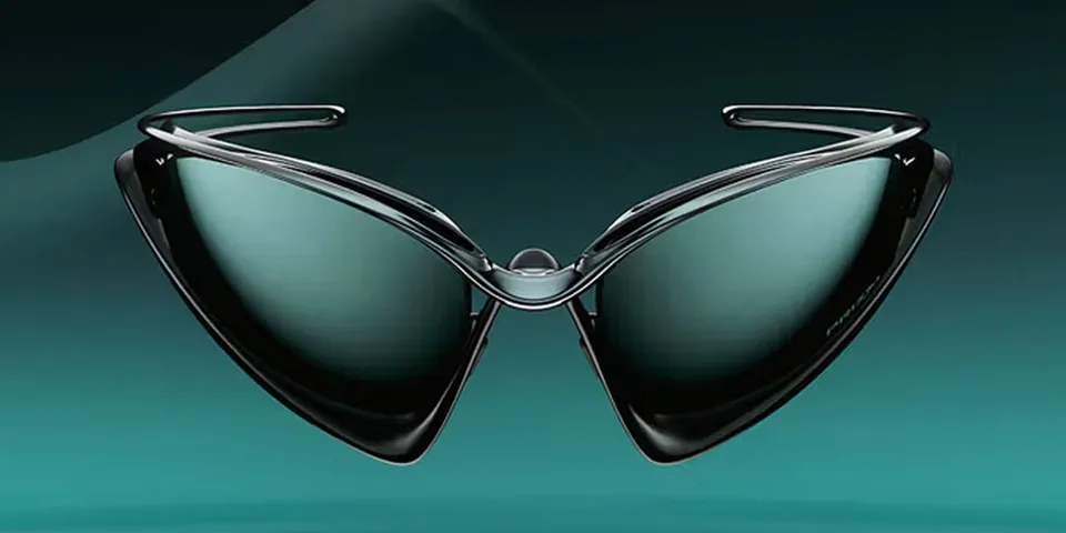 Lunettes de soleil futuristes sur fond vert, forme triangulaire élégante.