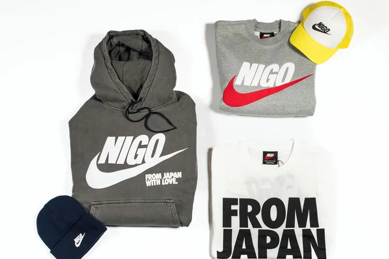 Sweats et casquette avec logos stylisés Nigo et Nike disposés sur une surface blanche.