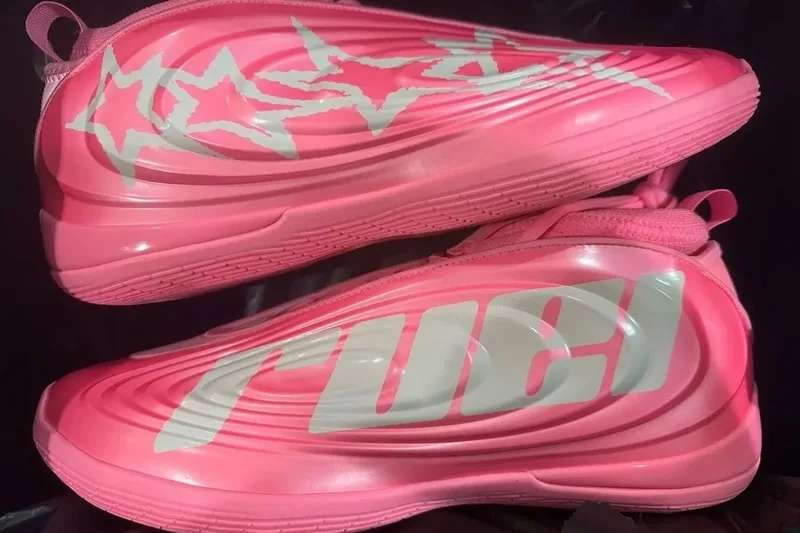 Chaussures roses avec motifs étoilés et texte blanc.