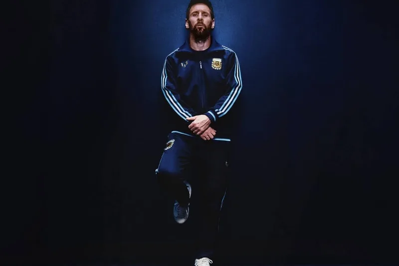 Homme en survêtement de l'équipe argentine, sur fond sombre.