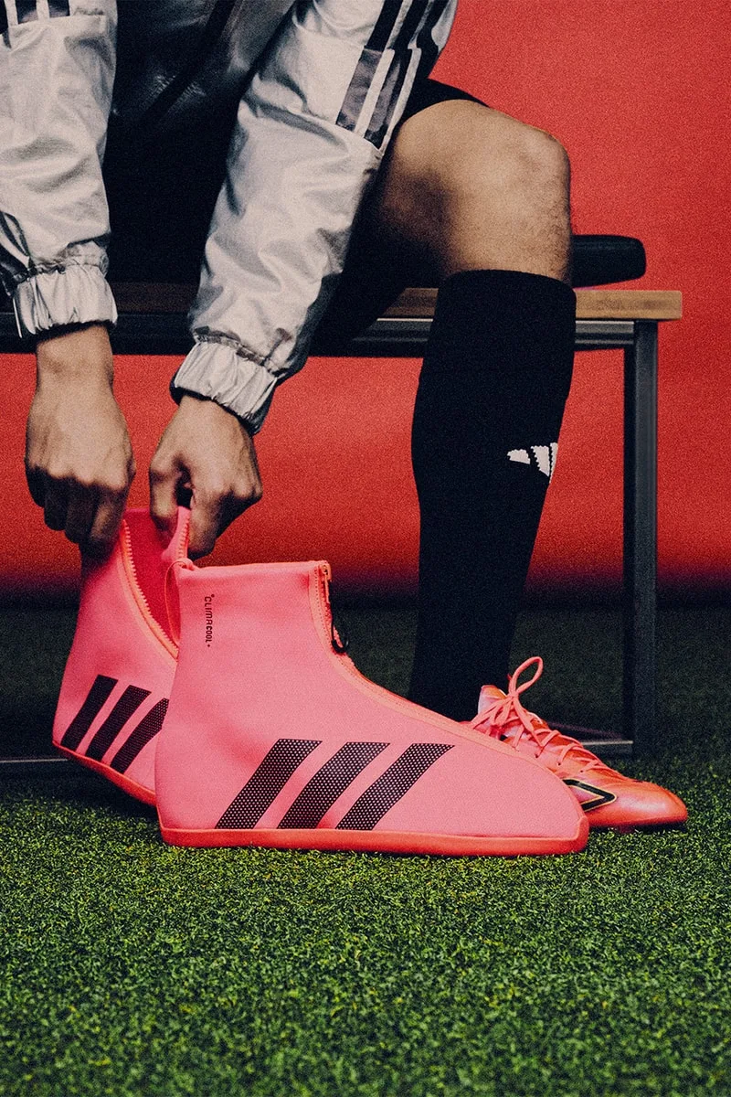 Personne portant des chaussures de sport roses avec des motifs noirs.