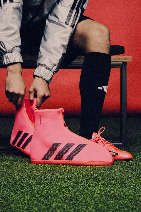 Personne portant des chaussures de sport roses avec des motifs noirs.