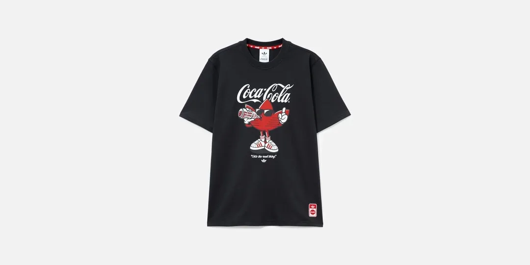 T-shirt noir Coca-Cola avec personnage rouge et bouteille.