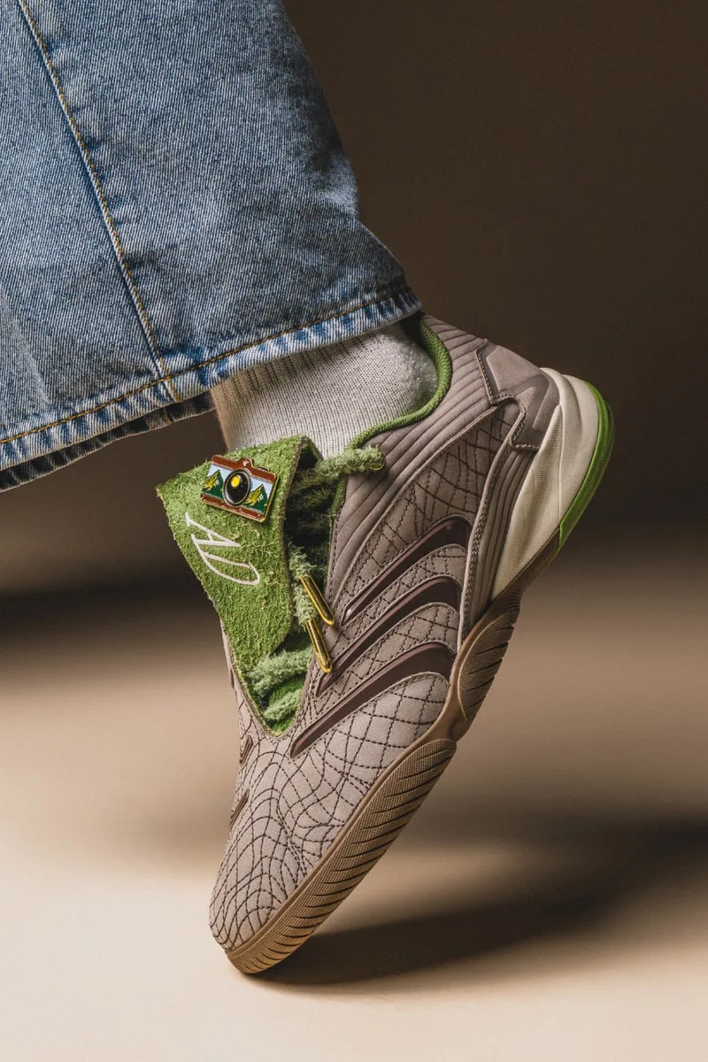 Chaussure avec motifs araignée et détails verts, portée avec jean.