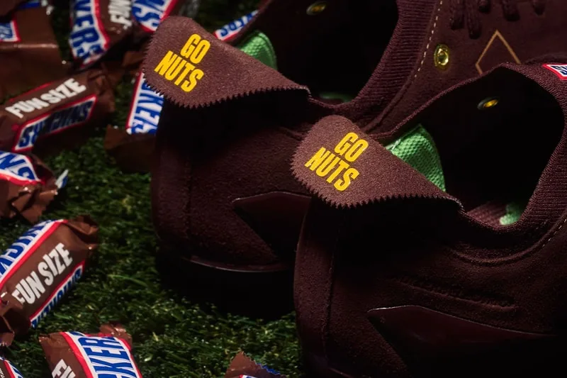 Chaussures marron 'Go Nuts' et barres Snickers sur gazon.