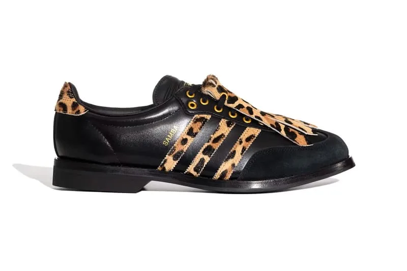 Chaussure noire avec motif léopard et trois bandes sur le côté.