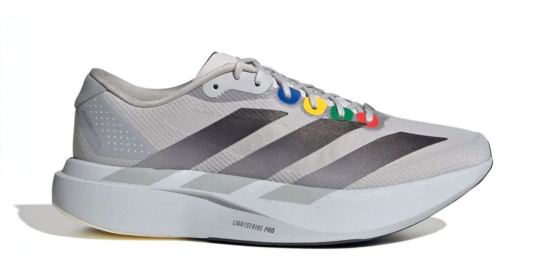 Chaussure de sport blanche avec détails colorés et rayures noires sur le côté