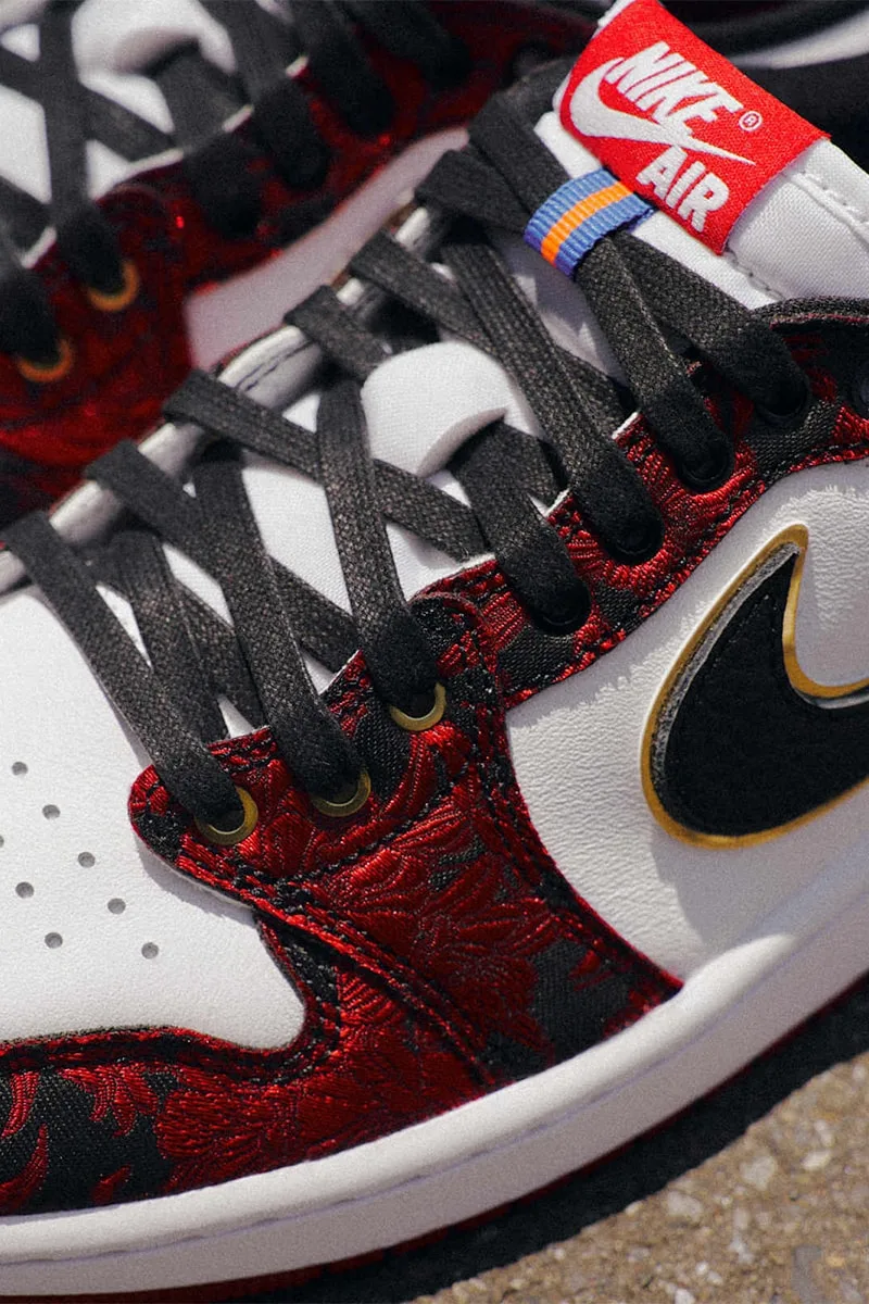 Chaussure Nike Air avec motif rouge et noir et logo doré.