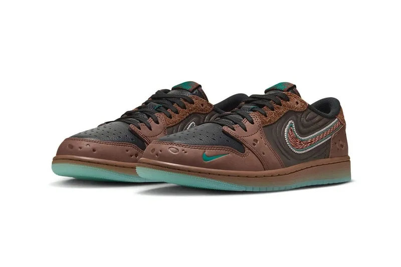 Chaussures de sport marron et noir avec logo bleu clair, semelles vertes.