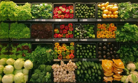 Rayons de supermarché remplis de légumes variés colorés, organisés parfaitement.