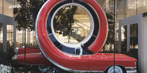 Voiture rouge en loop dans un décor moderne vitré.