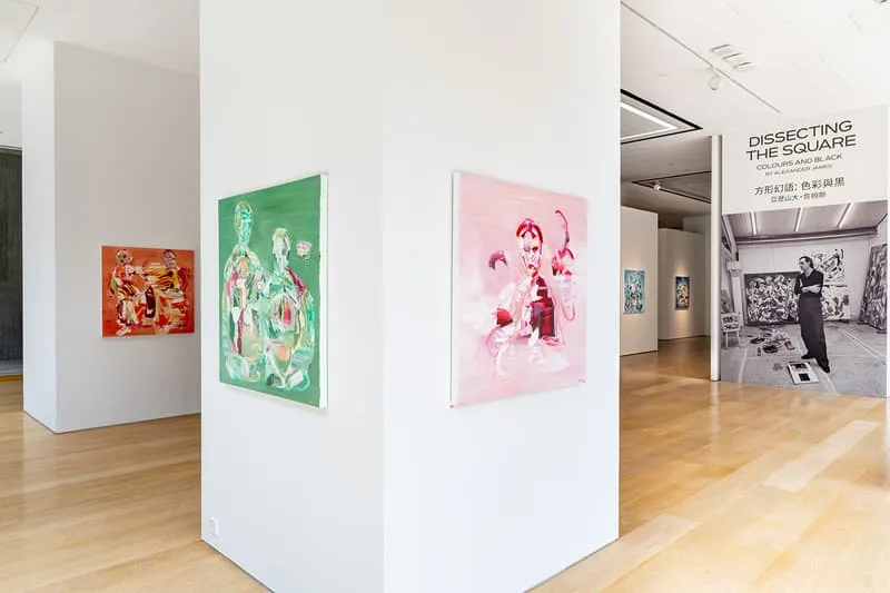 Exposition d'art avec peintures et panneau 'Dissecting the Square' en fond