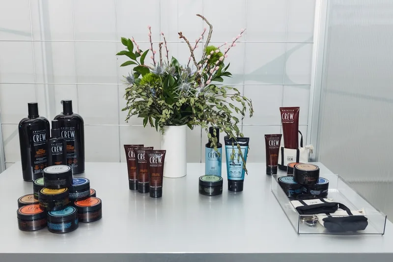 Produits de coiffure sur une table avec un bouquet de fleurs.