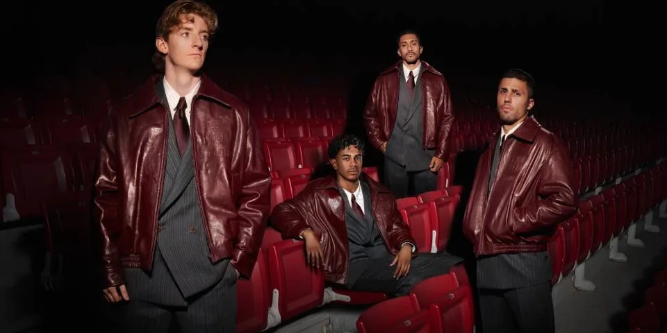 Quatre hommes en vestes de cuir posent dans une salle de cinéma aux sièges rouges.
