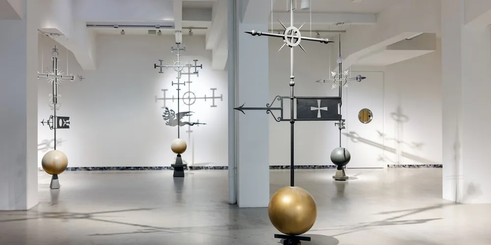 Sculptures métalliques modernes avec boules dorées et motifs géométriques dans une galerie.