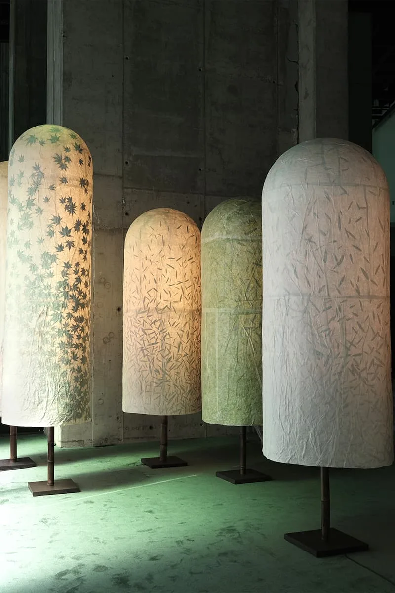 Lampes sur pied avec abat-jours en papier texturé et motifs naturels.