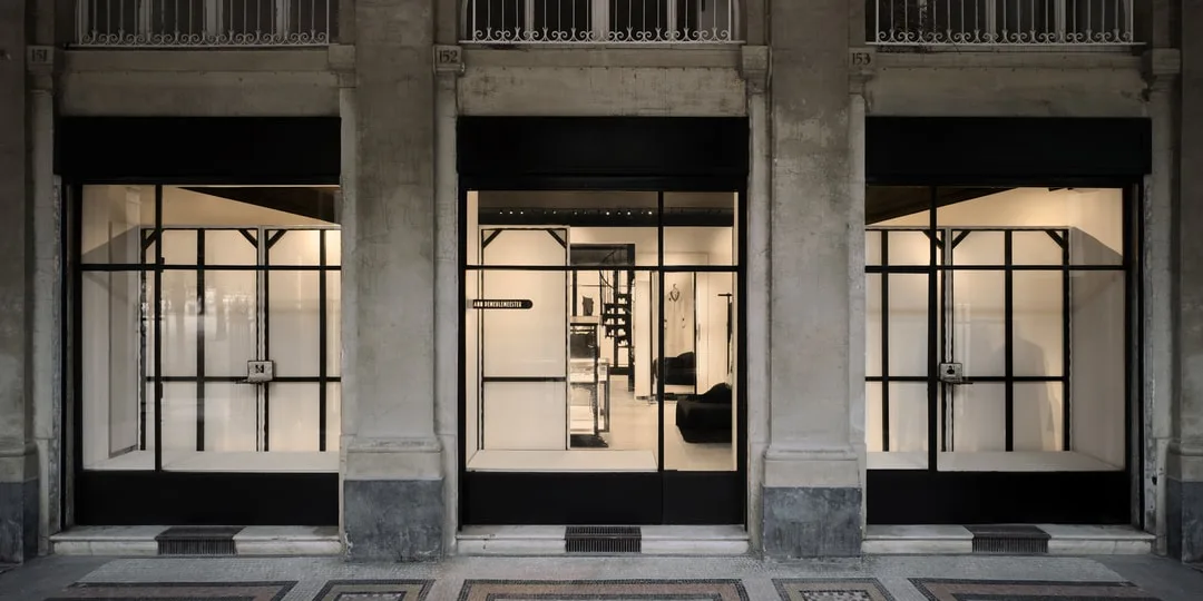 Façade d'un magasin moderne avec grandes vitrines et intérieur minimaliste.