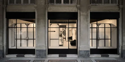 Façade d'un magasin moderne avec grandes vitrines et intérieur minimaliste.
