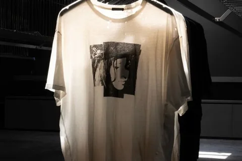 T-shirt blanc avec illustration en noir d'un visage sur fond gris.