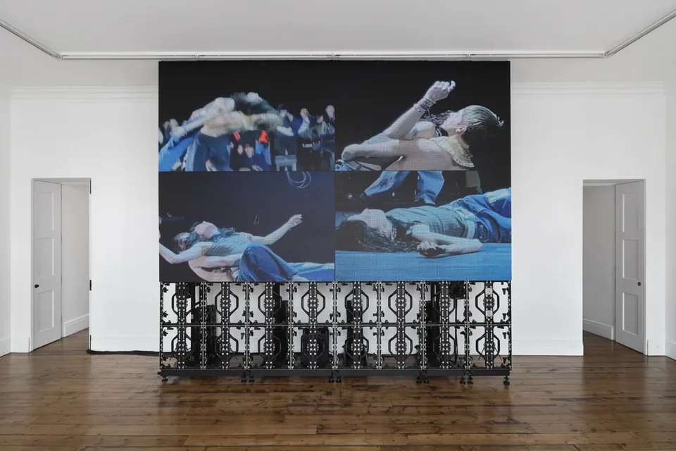 Grande image vidéo avec trois scènes de danse projetées sur écran mural.