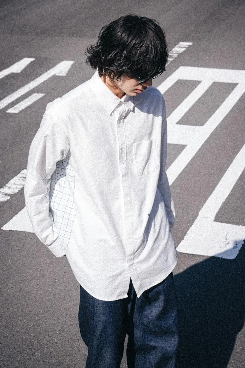 Personne portant une chemise blanche sur passage piéton.