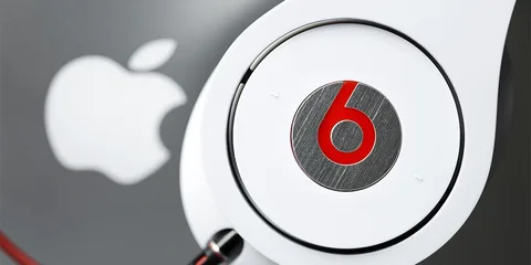 Casque Beats blanc devant un logo Apple argenté
