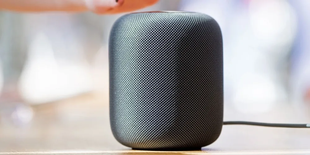 Enceinte intelligente noire sur une table en bois.