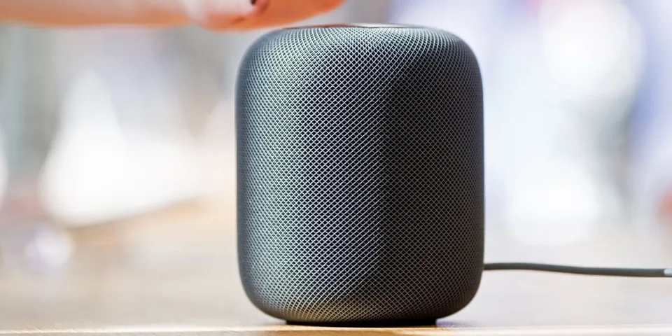 Enceinte intelligente noire sur une table en bois.