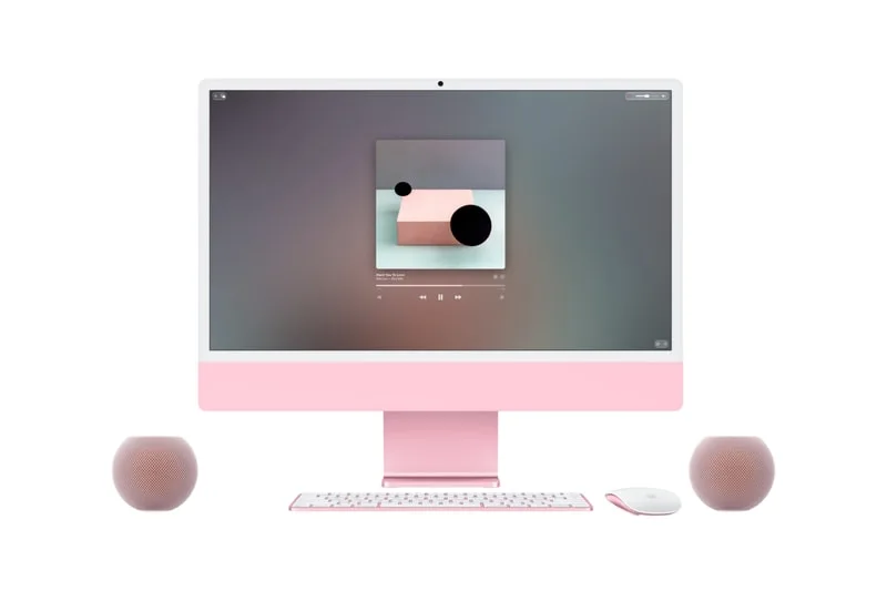 Ordinateur avec écran rose, deux enceintes et accessoires, fond graphique affiché.