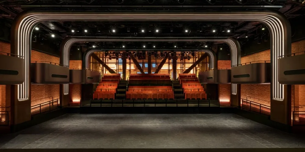 Intérieur d'une salle de spectacle moderne avec sièges et éclairage.