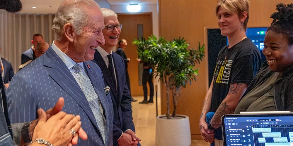 Personnes souriantes en discussion dans une salle avec des plantes.