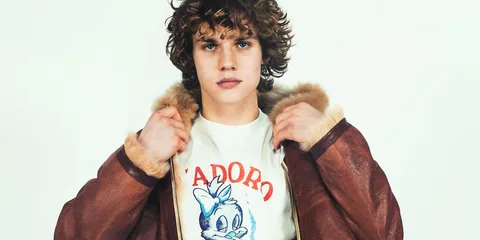 Jeune homme avec veste en cuir et t-shirt imprimé.