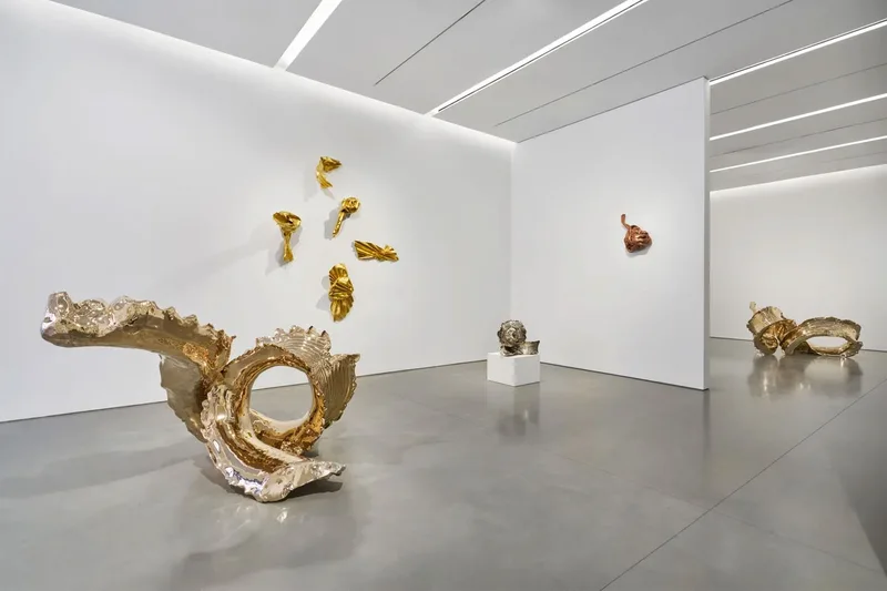 Sculptures dorées modernes dans une galerie d'art.