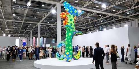 Sculpture colorée avec des motifs à pois dans une galerie bondée.