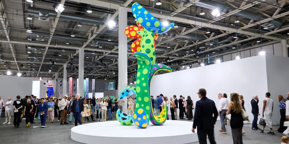 Sculpture colorée avec des motifs à pois dans une galerie bondée.
