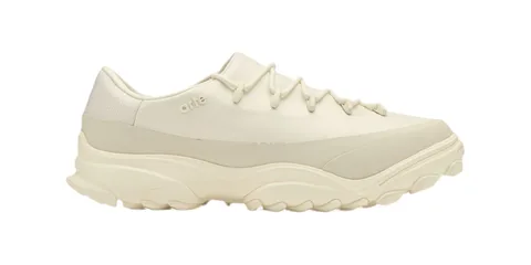 Chaussure de sport blanche avec semelle épaisse et lacets.