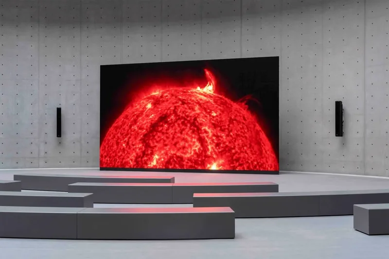 Salle avec écran affichant une image du soleil en gros plan.
