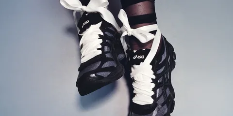 Chaussures de sport noires avec grands lacets blancs.