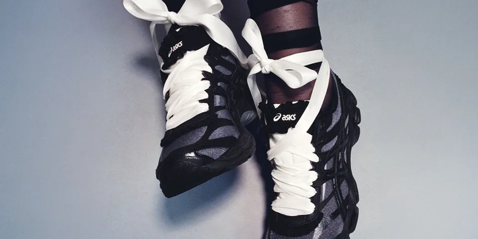 Chaussures de sport noires avec grands lacets blancs.